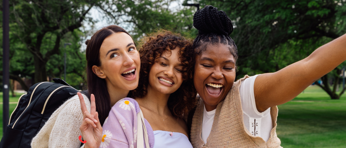 three students smiling and posing together