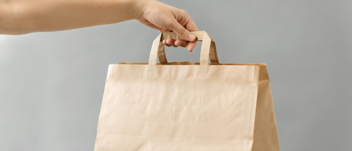 someone holding up paper bag