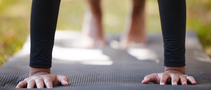 Person Stretching on Yoga Mat Outside