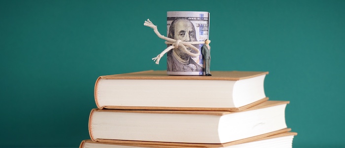 Roll of Bills on Top of Stacked Books