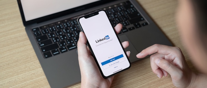 Person Holding Phone Accessing LinkedIn App