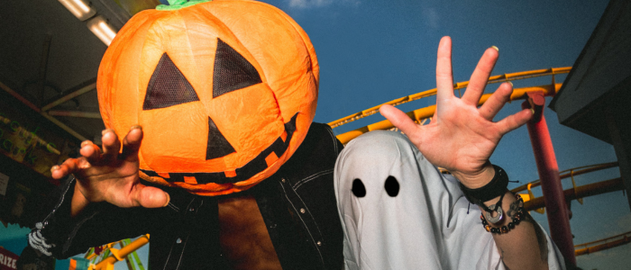 people in ghost and pumpkin head costumes