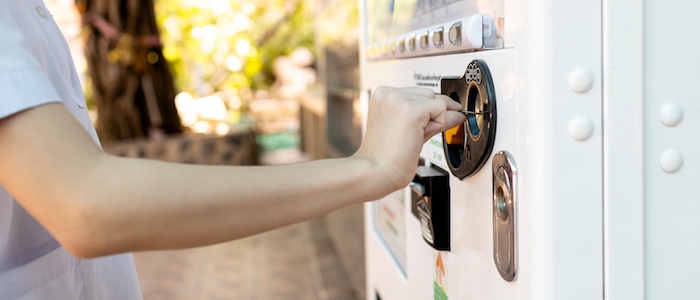Person inputting credit card into vending machine