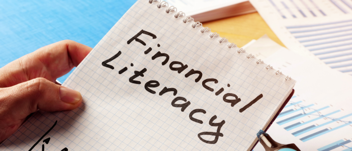 person writing financial literacy on notepad