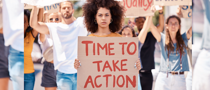 Slam Poet Holding a Time to Take Action Sign