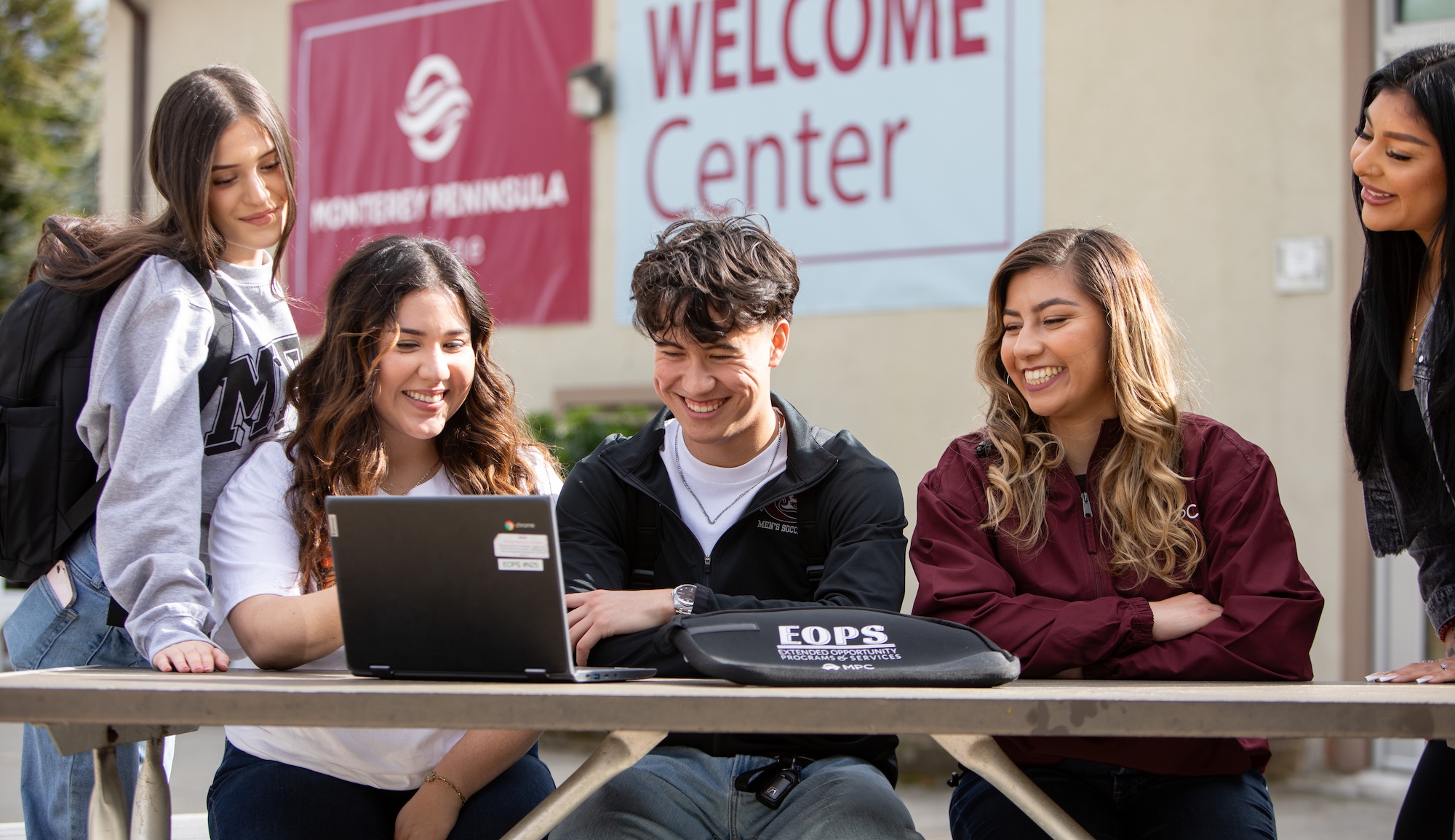 mpc students working on computer together outside